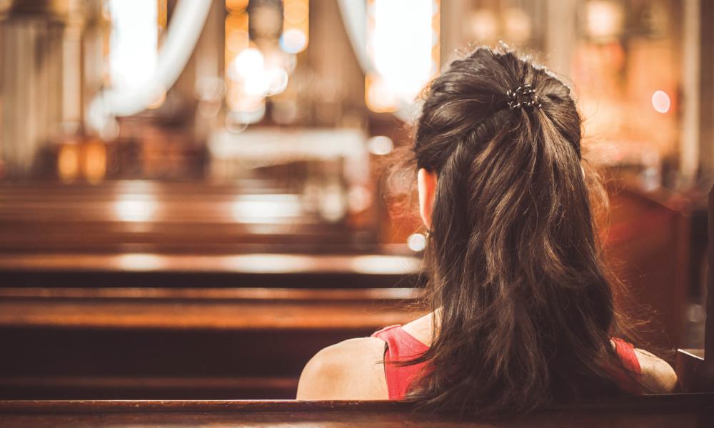 senior woman sitting in church pew.