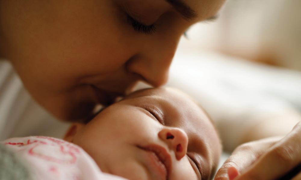 Mother kissing her baby.