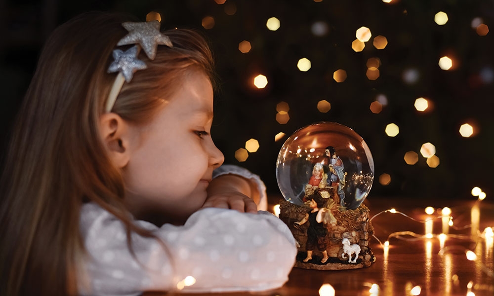 Young girl gazing at a Nativity scene