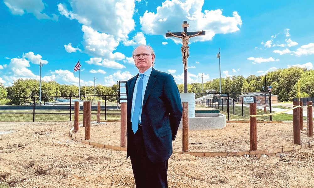 Tim DeWitt, President of Lumen Christi Catholic School, stands in front of the Jackson school’s new 16-foot crucifix