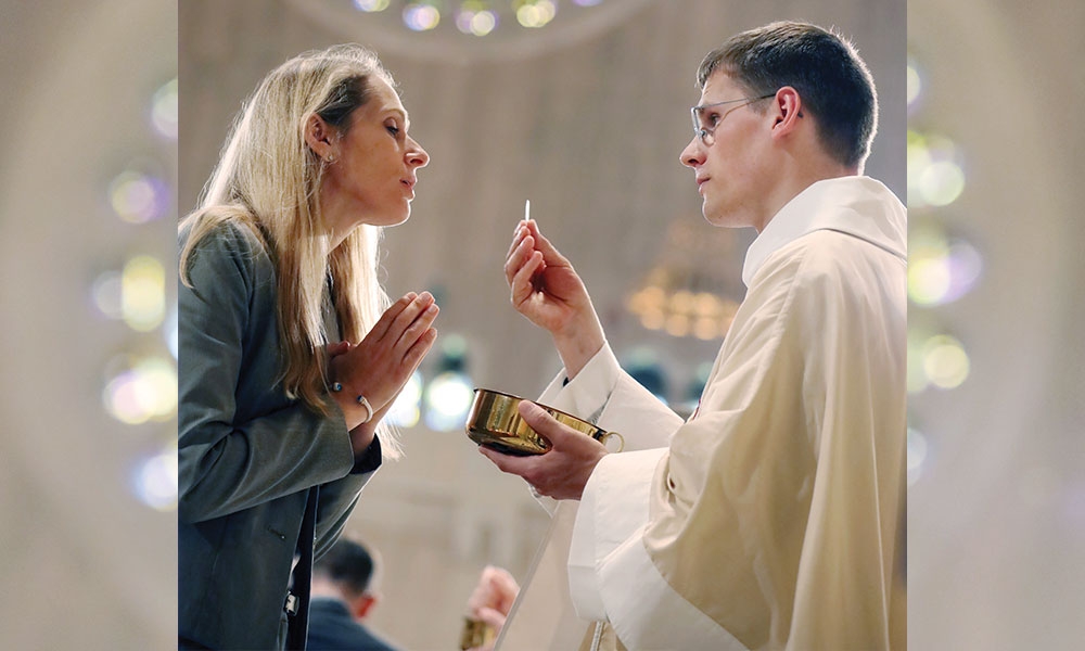 Woman receiving Eucharist from priest