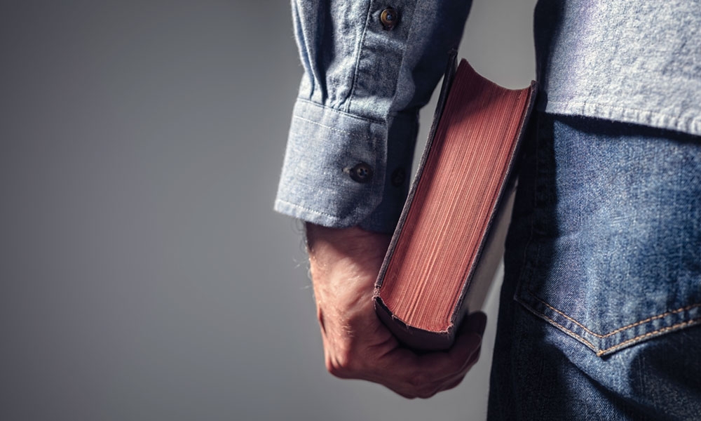 Person holding book by side