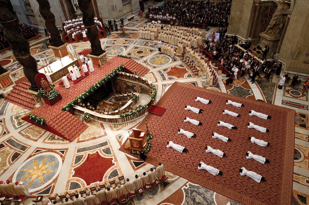 Newly ordained priests lie prostrate as Pope Francis leads a Mass in St. Peter Basilica at the Vatican, April 22