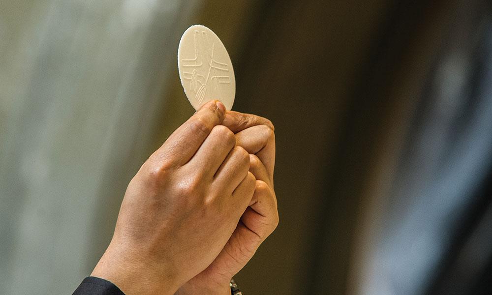 Eucharist raised in priest's hands