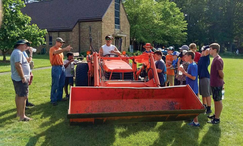 Boys at St. Francis Retreat Center in DeWitt around a tractor