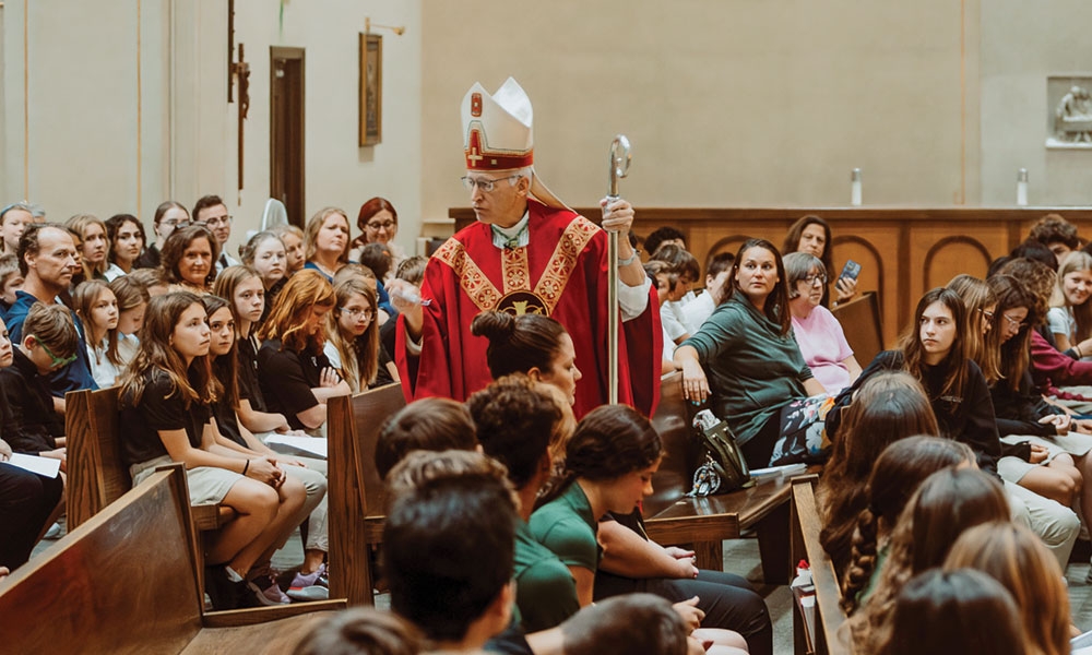 Bishop Boyea preaching in the middle of students during Mass