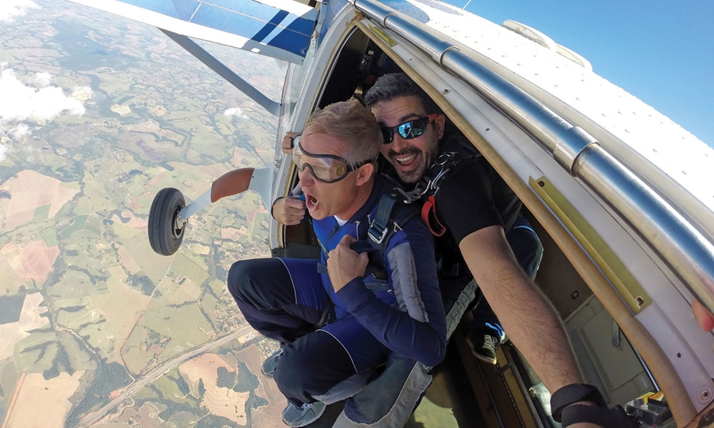 Two people jumping out of a plane to skydive